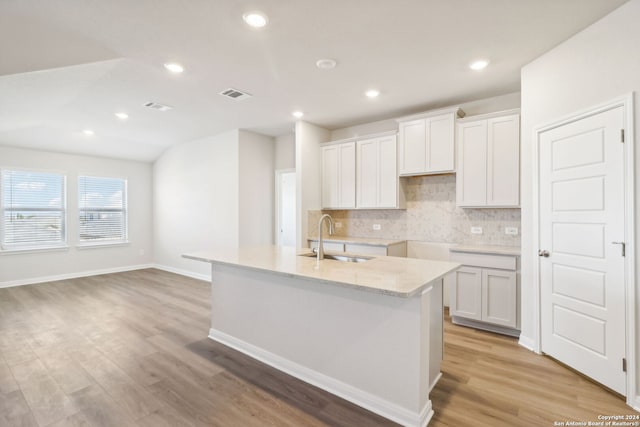 kitchen featuring a center island with sink, white cabinets, light hardwood / wood-style floors, and sink