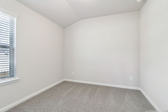 unfurnished room featuring carpet floors and lofted ceiling