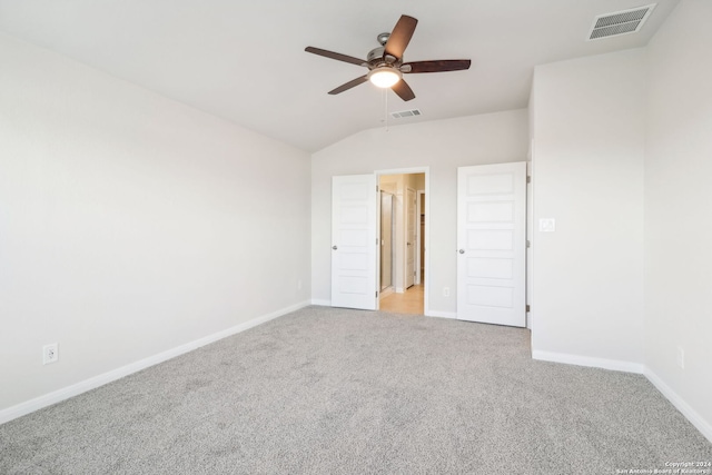 unfurnished bedroom with ceiling fan, lofted ceiling, and light carpet