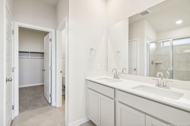 bathroom with tile patterned floors, vanity, toilet, and an enclosed shower