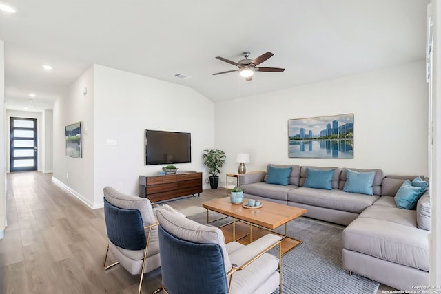 living room featuring light wood-type flooring, vaulted ceiling, and ceiling fan