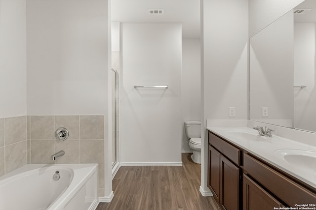 bathroom featuring vanity, hardwood / wood-style floors, a bathtub, and toilet