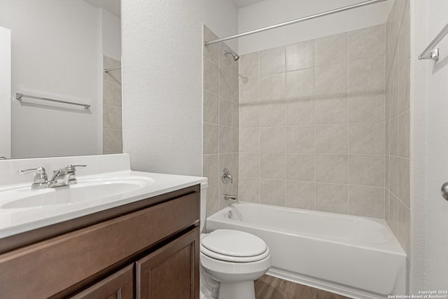 full bathroom featuring vanity, hardwood / wood-style flooring, toilet, and tiled shower / bath combo