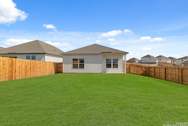 rear view of property with a yard