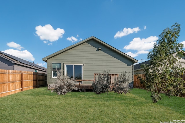 back of house with a lawn and a deck