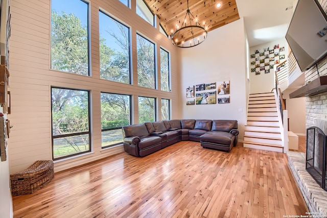 living room featuring light hardwood / wood-style flooring, high vaulted ceiling, wood ceiling, and a brick fireplace