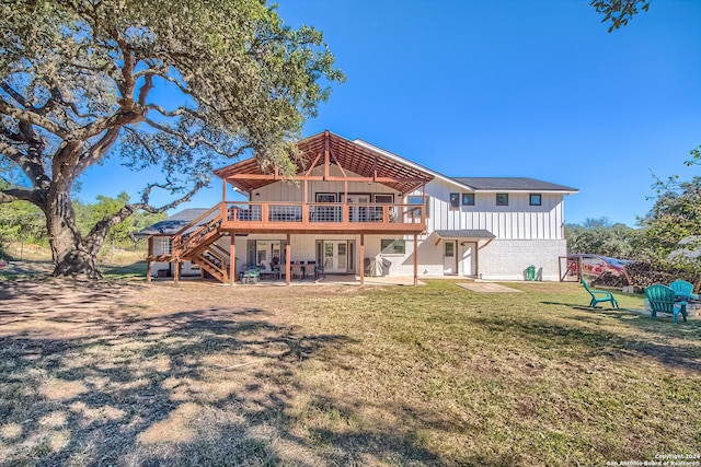 back of property with a yard, a patio area, and a wooden deck