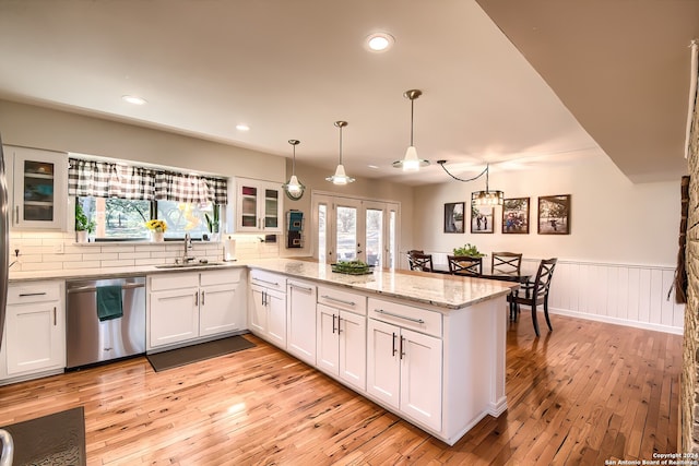 kitchen featuring stainless steel dishwasher, white cabinets, sink, and light hardwood / wood-style flooring