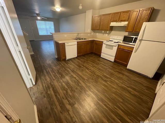 kitchen with dark hardwood / wood-style floors, white appliances, sink, and kitchen peninsula