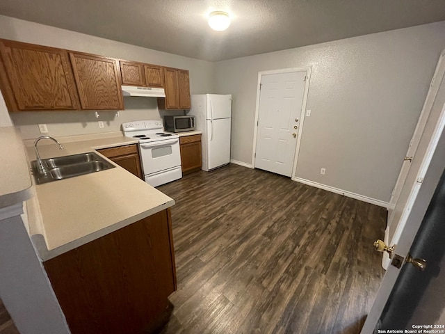 kitchen with white appliances, dark hardwood / wood-style floors, and sink