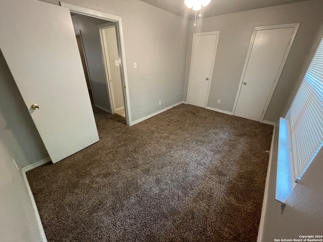 unfurnished bedroom featuring dark colored carpet