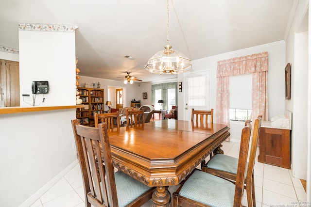 dining area with ceiling fan with notable chandelier, light tile patterned floors, and crown molding