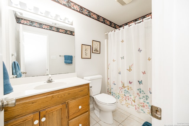 bathroom featuring tile patterned flooring, vanity, toilet, and walk in shower