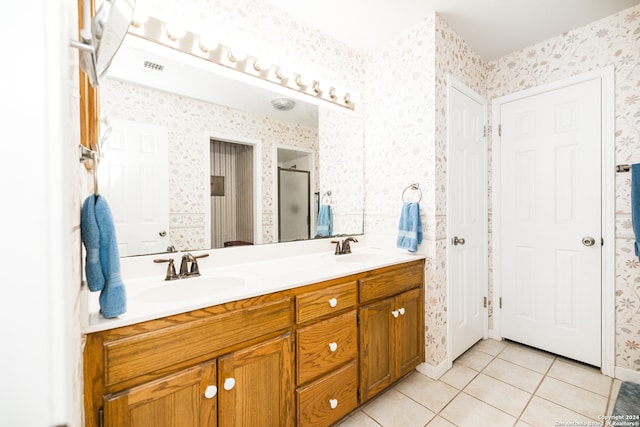 bathroom with tile patterned flooring, vanity, and a shower with door