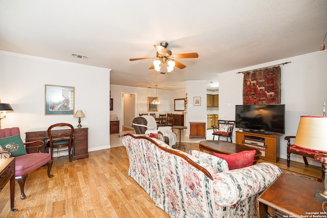 living room featuring ceiling fan, light wood-type flooring, and crown molding