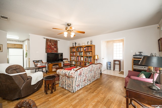 living room featuring ceiling fan, light wood-type flooring, and ornamental molding