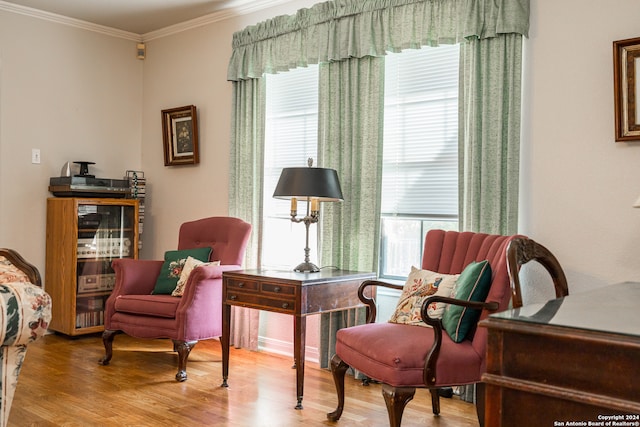 living area featuring light hardwood / wood-style flooring and crown molding