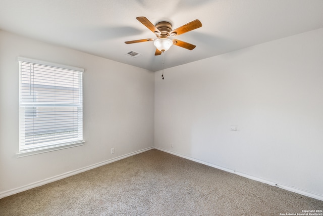 carpeted empty room with ceiling fan and a healthy amount of sunlight