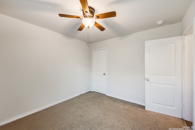 carpeted empty room featuring ceiling fan