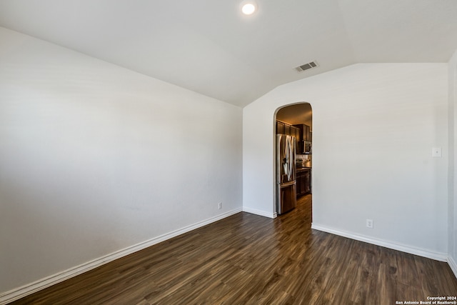 empty room with dark hardwood / wood-style floors and vaulted ceiling