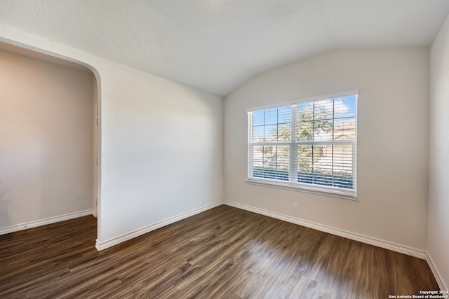 unfurnished room with dark hardwood / wood-style flooring and lofted ceiling