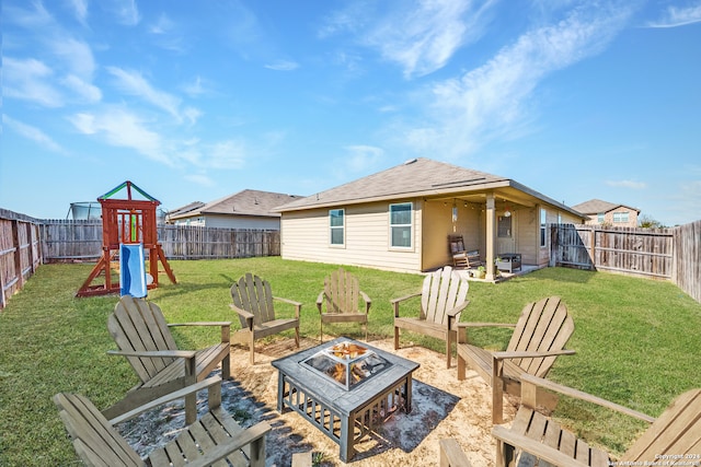 exterior space with a playground, a fire pit, and a lawn