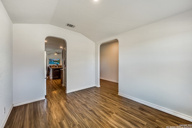 unfurnished room with vaulted ceiling, ceiling fan, and dark wood-type flooring