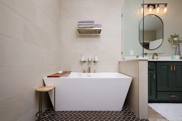 bathroom featuring a tub to relax in, vanity, and tile walls