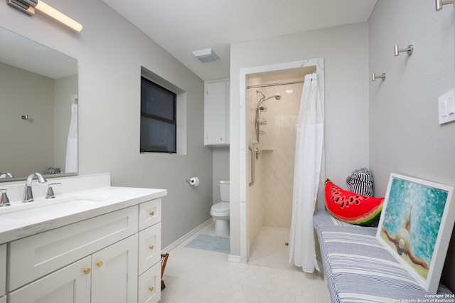 bathroom featuring tile patterned flooring, vanity, toilet, and walk in shower