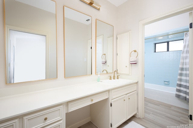 bathroom featuring hardwood / wood-style flooring, vanity, and shower / tub combo