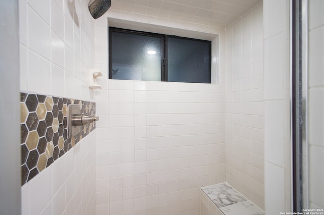 bathroom featuring walk in shower and tile walls