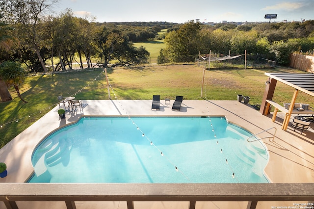 view of pool with a patio and a lawn