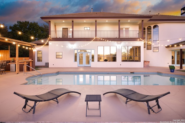 pool at dusk featuring a patio area