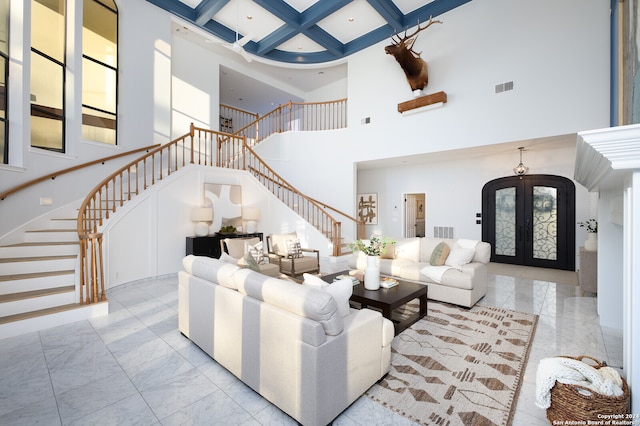 living room featuring beam ceiling, french doors, a towering ceiling, and coffered ceiling