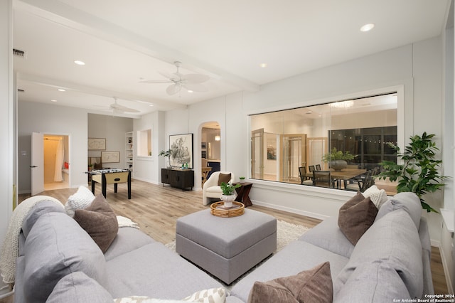 living room featuring beamed ceiling, ceiling fan, and light hardwood / wood-style flooring