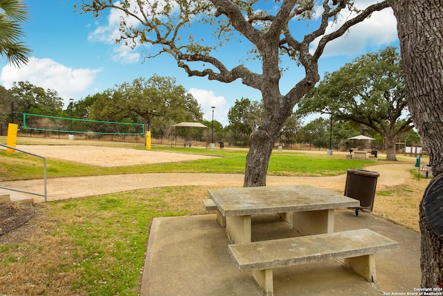 view of property's community with volleyball court and a yard