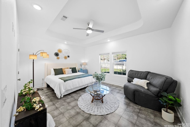 bedroom featuring a raised ceiling and ceiling fan