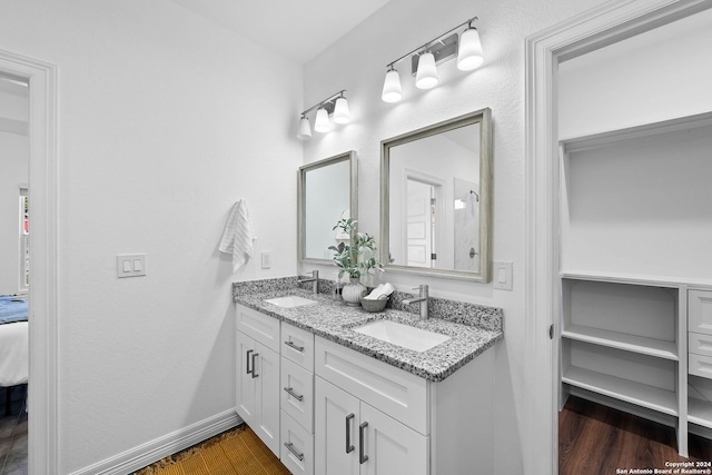 1153 Singing Hills Dr, Canyon Lake, TX 78133 - ensuite bathroom with double vanity, wood finished floors, and baseboards