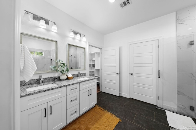 bathroom featuring tile patterned floors, vanity, and a shower with shower door