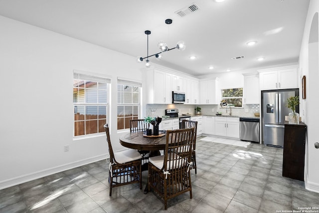 dining space featuring a wealth of natural light, sink, and a notable chandelier