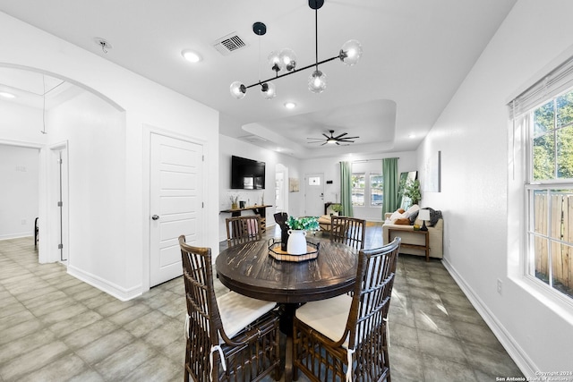 1153 Singing Hills Dr, Canyon Lake, TX 78133 - dining area with baseboards, a ceiling fan, recessed lighting, a tray ceiling, and arched walkways