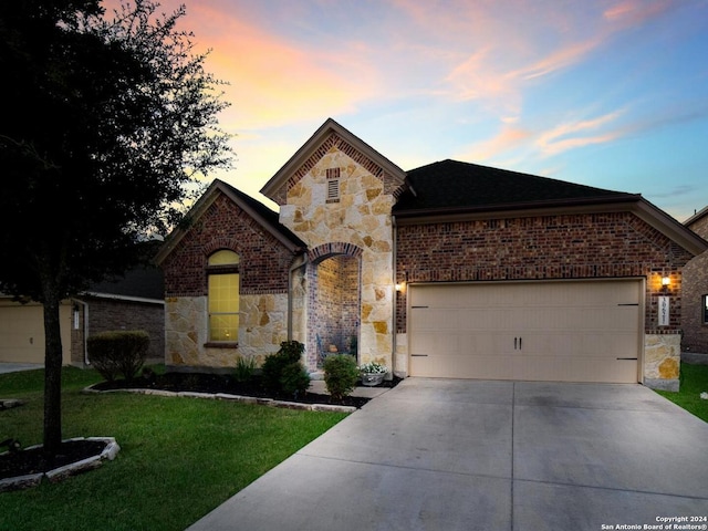 view of front of home with a garage and a yard