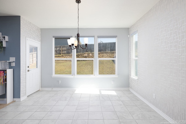 unfurnished dining area featuring a chandelier, plenty of natural light, and brick wall