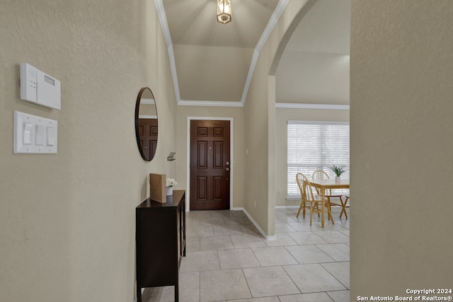 tiled entrance foyer with vaulted ceiling and ornamental molding