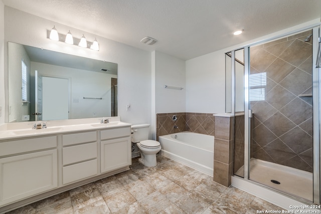 full bathroom featuring vanity, toilet, separate shower and tub, and a textured ceiling