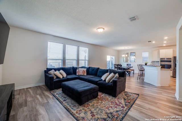 living room featuring light hardwood / wood-style floors and a textured ceiling