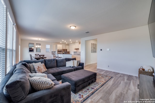 living room featuring a notable chandelier and light wood-type flooring