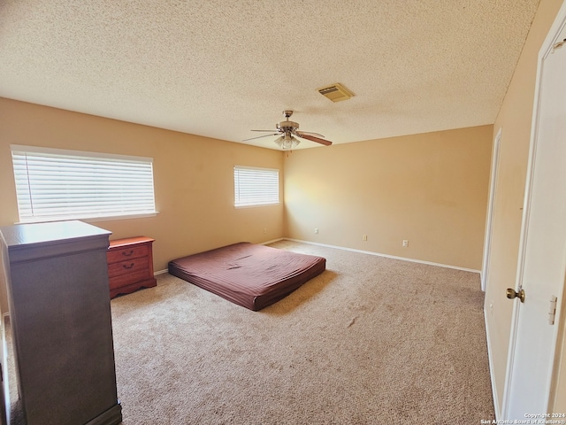 carpeted bedroom with a textured ceiling and ceiling fan