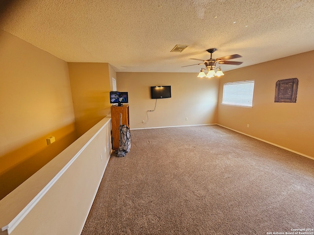 carpeted empty room featuring ceiling fan and a textured ceiling