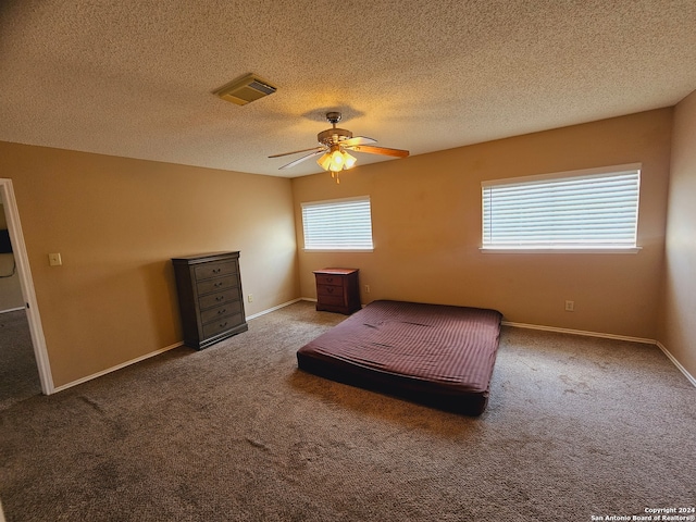 bedroom featuring ceiling fan, carpet floors, and a textured ceiling